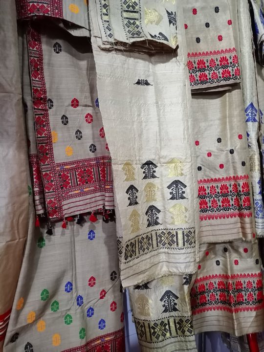 Assamese mekhela chadors with woven motifs hanging on display
